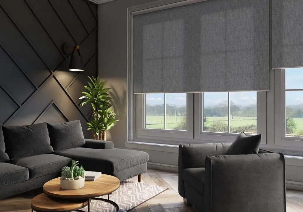 A grey roller blind pulled down over a living-room window